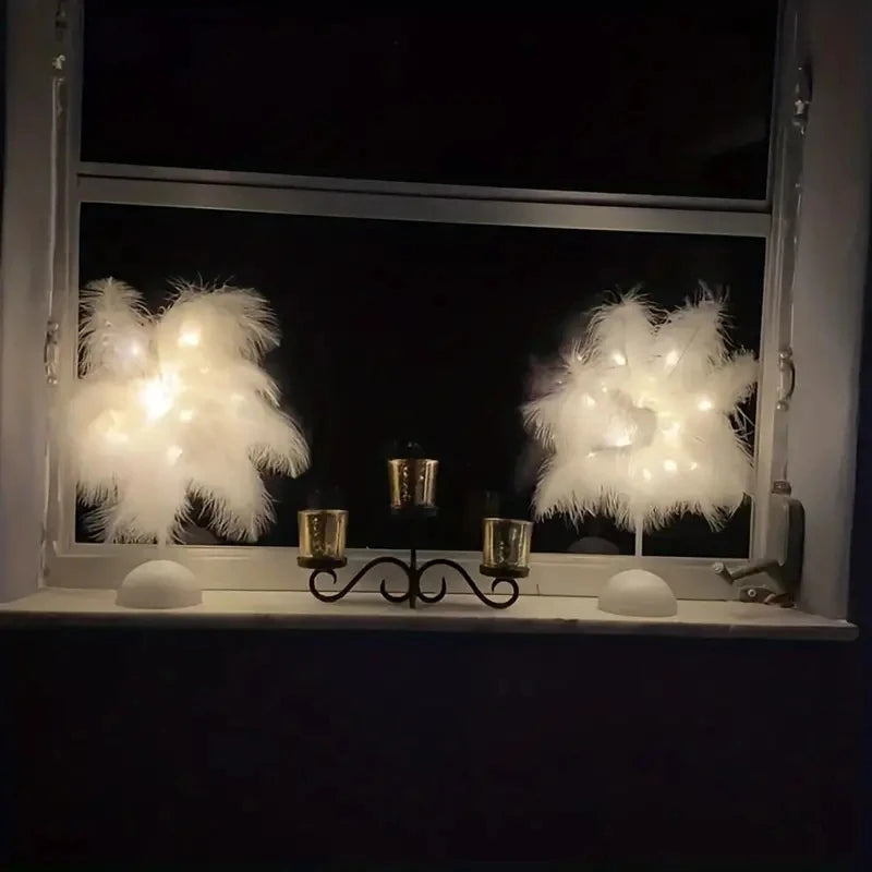 Two feather LED lamps glowing on a windowsill beside candle holders