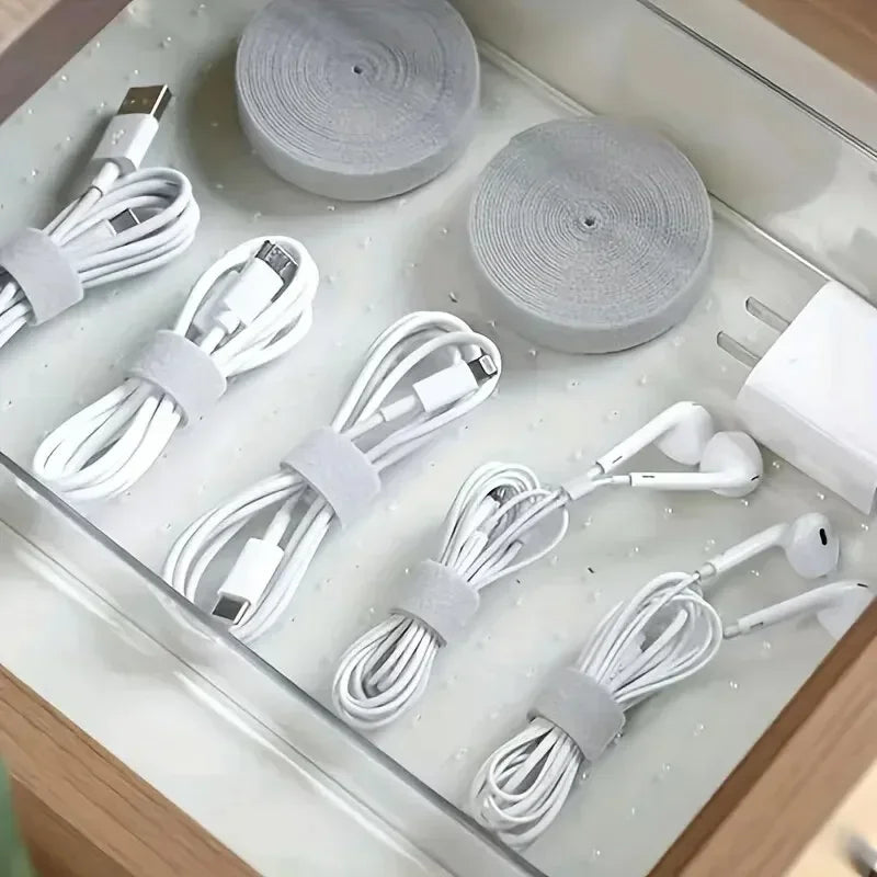 Charging cables coiled with white cable wrap organized in a drawer