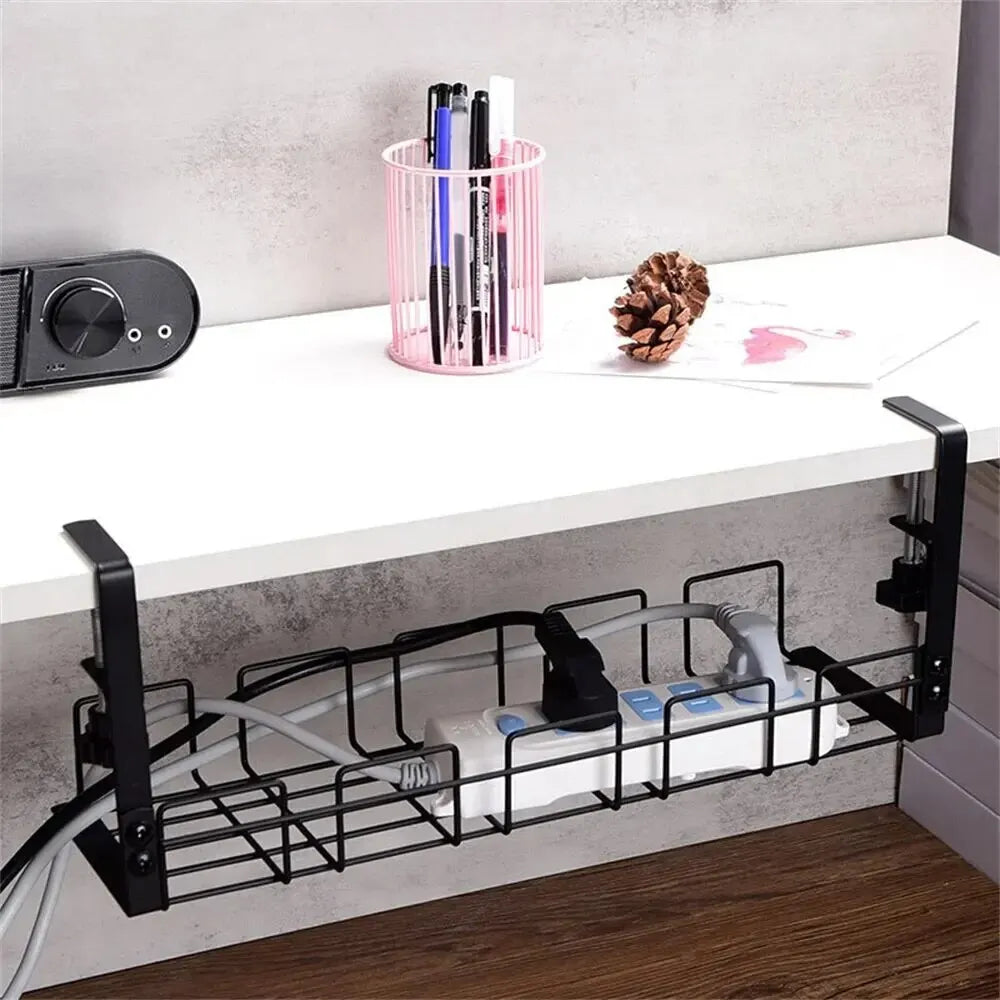Under-desk wire tray holding a power bar along a white wall-mounted desk