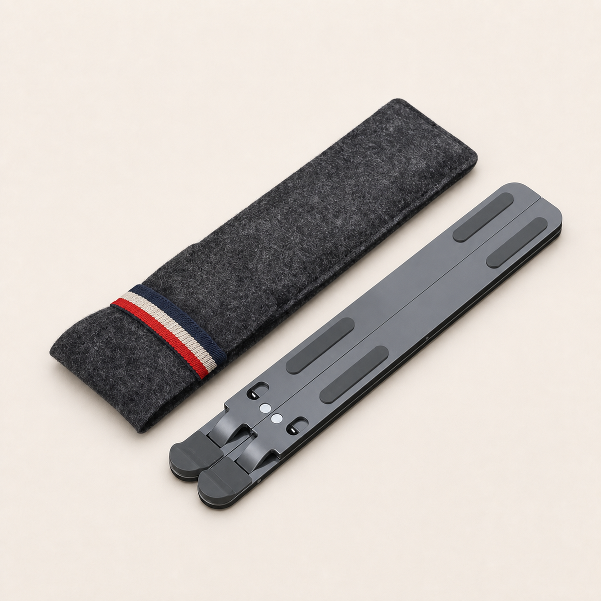Folded gray P11 aluminum laptop stand with felt sleeve on a warm off-white background