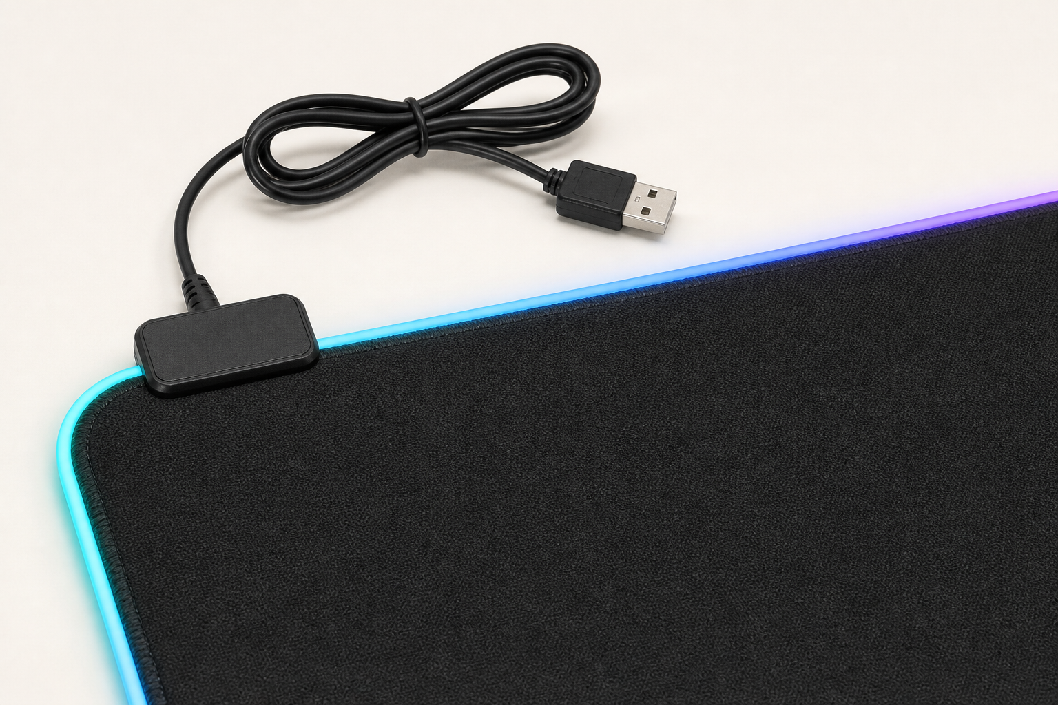 Close view of the RGB desk mat stitched edge, controller and USB power cable