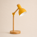 Yellow wood turn-head table lamp on a square off-white studio background